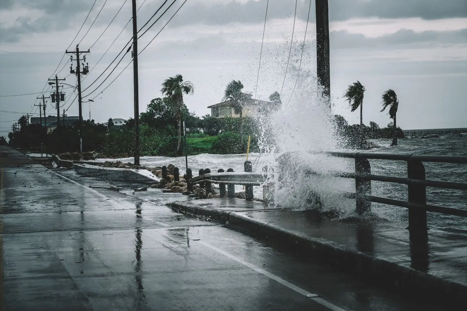 Storm at the sea with big waves splashing over to the sidewalk.