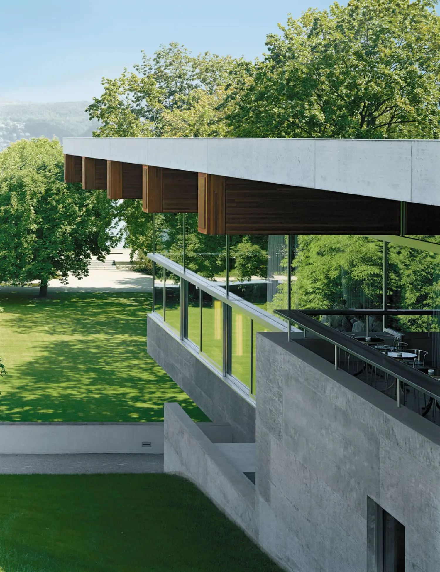 A gray, concrete side of the Centre of Global Dialogue building facing the lawn.