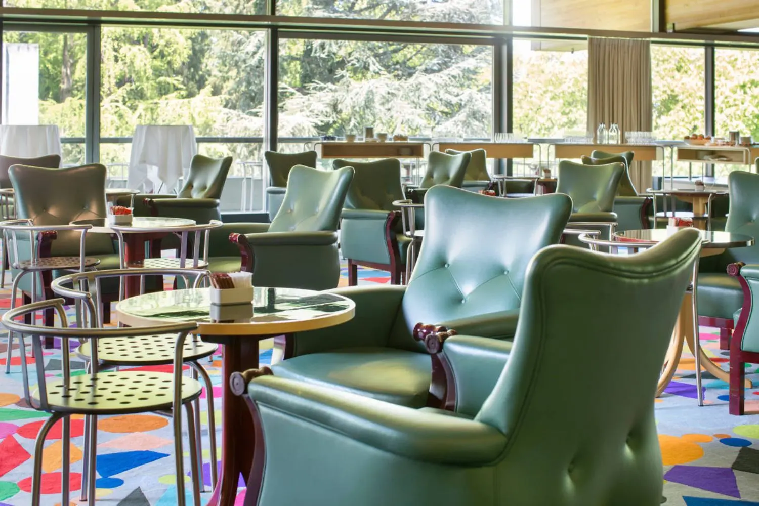 Lounge chairs and coffee tables on a bright colored carpet.
