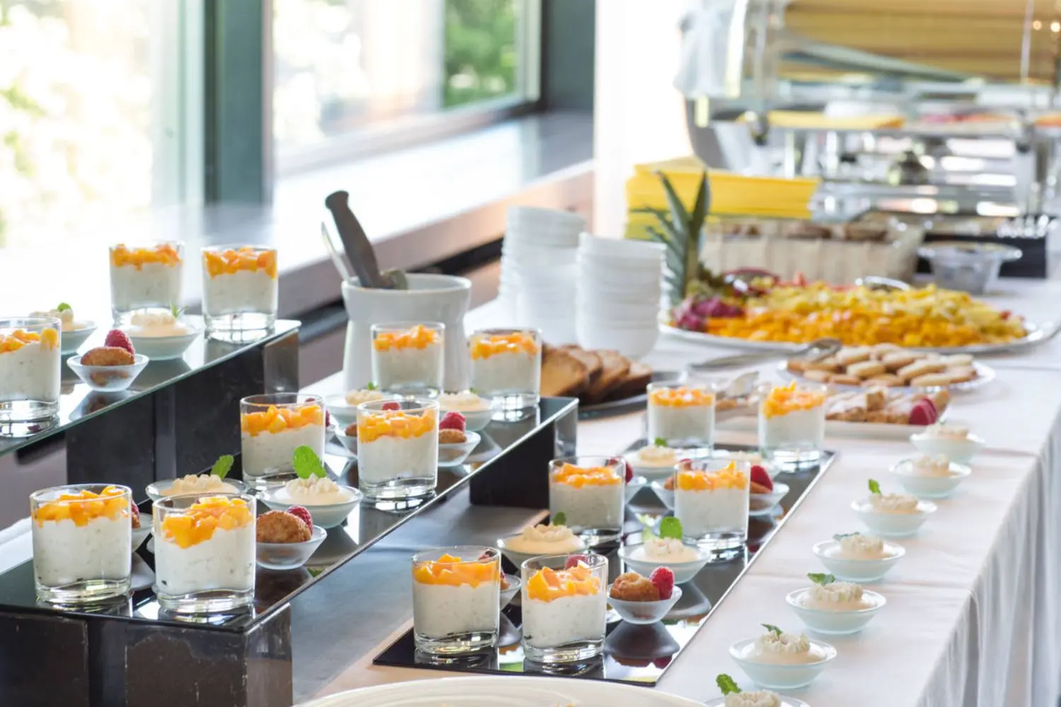 A row of desserts on a white table cloth.
