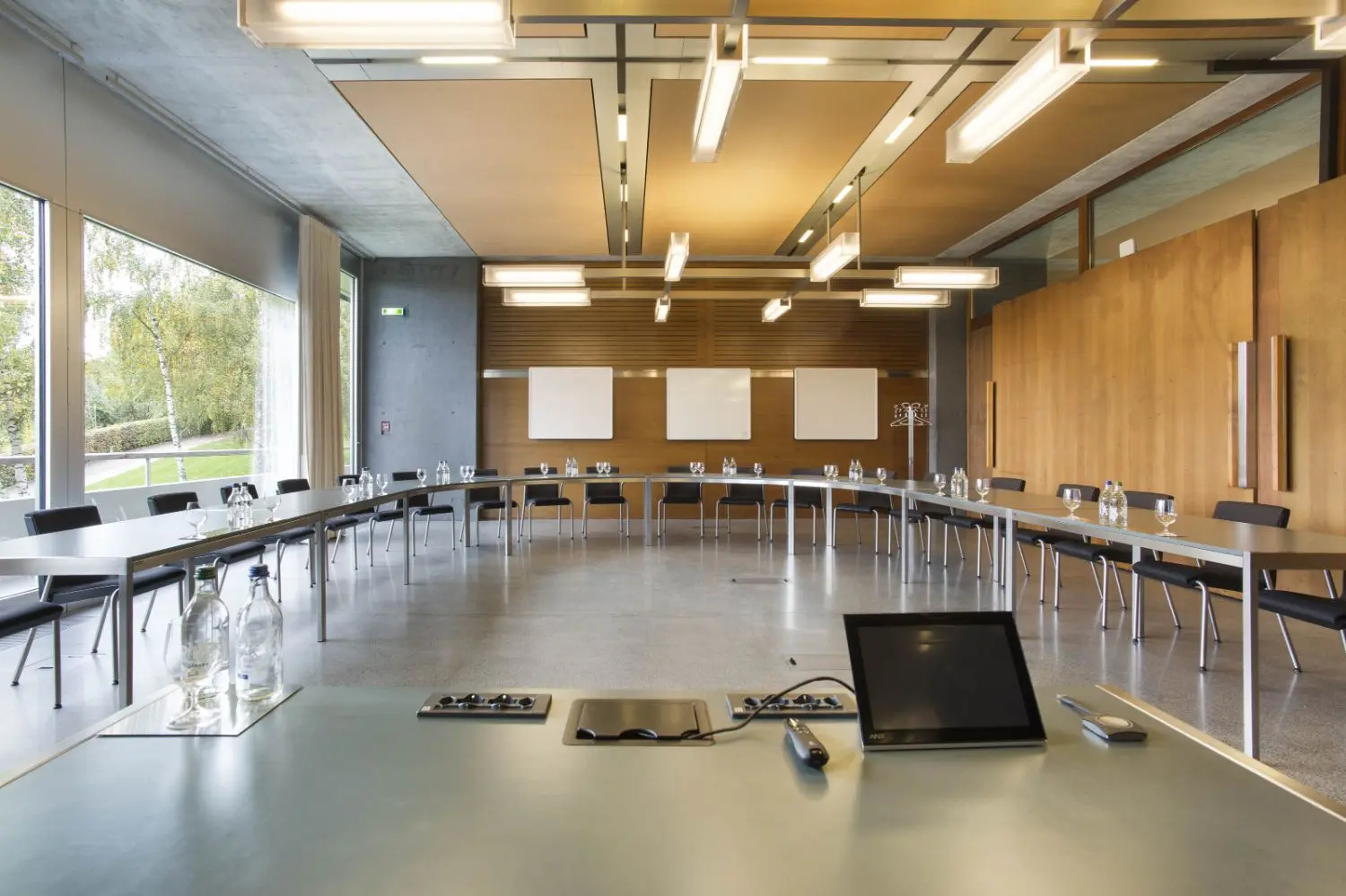 Tables and chairs arranged in a U shape facing a podium.