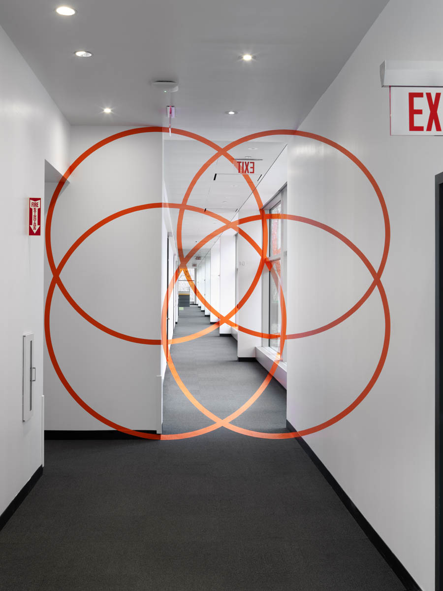 Just an illusion: from one particular point of view – it seems four interconnecting orange circles block one's passage though another corridor.
